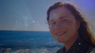 Güneş ışığı parlayan teknolojisi, kameraya bakan, gülümseyen ve okyanusu yansıtan bir kadınla örtüşüyor. Manzara, dinginlik, dijital sanat, doğa, farkındalık, açık hava, sükunet