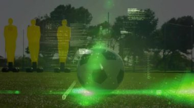 Yeşil spor analizlerine rehberlik ederken futbolcu mankenlerin yanından geçip topa vuruyor. Teknoloji, eğitim, performans, hareket, atletik, spor, dijital