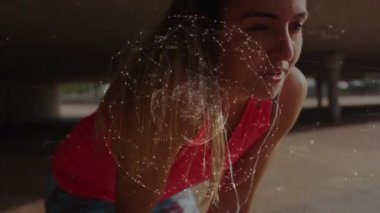 Dizlerinin üstüne çöküp ellerini destekleyen bayan sporcu teknoloji gösterisi için dönen kablo çerçevesi küresini başlatıyor. Gelecek, teknoloji, yenilik, dijital, ağ, bağlantı, soyutlama