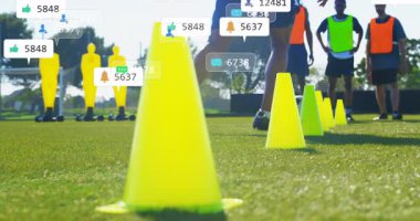 Oyuncu içeri giriyor, futbol antrenmanı için külahların önünden geçiyor ve animasyon simgeleriyle nişan gösteriyor. Atletik, açık hava, spor, dinamik, dijital, takım çalışması, rekabet