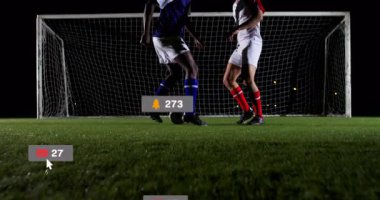 İki erkek sporcu top kontrolü için koşuşturuyor, yükselen sosyal medya rozetleri takıyor. Sporcular, yarışma, spor, takım çalışması, çeviklik, dijital bağlılık, gece