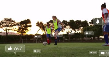 Oyuncu, sosyal simgeleri aktifleştiriyor rakibi kayıyor, top sürüyor, düşüşe ve duraklamaya neden oluyor. Atletik, takım çalışması, aksiyon, performans, rekabet, açık hava, canlılık