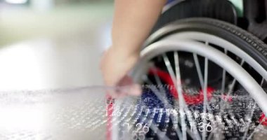 Tekerlekli sandalyenin kenarını iten ve rehabilitasyon için iten bir kadın. Bu arada rakamsal veriler sürükleniyor. Rehabilitasyon, asist teknoloji, hareket, veri görselleştirme, hareketlilik, terapi, fütüristik