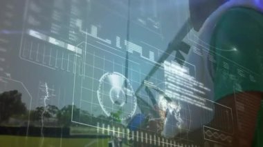 Yeşil futbolcu bilek cihazını kontrol ederken spor ölçümlerine neden oluyor. Sporcular, takım çalışması, performans, açık hava, teknoloji, fitness, yarışma