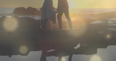 Çıplak ayaklı, etek ve kot pantolon giyen çift günbatımı kayalık iskelede, havuz ve kayalarla el ele tutuşuyor. Romantik, dinginlik, doğa, macera, uyum, keşif, açık hava