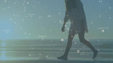 Kadın plaj güneşine giriyor, yürümeden önce kabuk toplayarak veri düğümlerini etkinleştiriyor. Deniz manzarası, bağlantı, sükunet, düşünceli, minimalist, dijital arayüz, doğal ışık