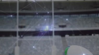 Ağ düğümleri titreşiyor ve sürükleniyor, ragbi topu sahada kırmızı tee vuruşu noktasında beliriyor. Stadyum, spor, atletizm, teknoloji, ağ, dijital, rekabet