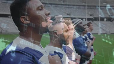 Futbolcular marş söylüyor, kamera takılıyor, bulmaca parçalarıyla haritalar gösteriliyor. Takım, sporcular, stadyum, açık hava, performans, birlik, dijital