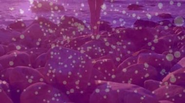 Gün batımı sahilinde ağırlık değiştiren bir kadın teknoloji gösterisinde rüzgâr oklarını örtüyor. Sahil şeridi, dinginlik, hareket, özgürlük, rahatlık, manzara, doğal