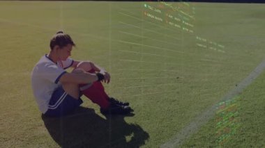 Futbolcu oturmuş, holografik performans gösterge panelinin teknoloji analizi için oluşumunu izliyor. Atletik, fütüristik, görselleştirme, spor, dijital, yenilik, sağlık