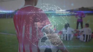 Futbolcu topu tutuyor, başını kameraya çeviriyor, atımlı holografik küreyi çalıştırıyor. Atletik, takım çalışması, dijital, yenilik, spor, eğitim, bağlantı