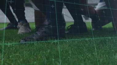 Oyuncuların bacak yastıklı topuna girerken şebeke darbeleri talim sırasında kameraya doğru tekmeliyor. Spor, takım çalışması, çeviklik, gerçekçilik, eğitim, teknoloji, fitness