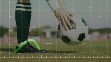 Eldivenli el topu krampona yerleştirirken atlet ayak ve analitik çizelge tekmeleme topunu ayarlıyor. Spor, biyomekanik, performans, eğitim, hareket, analitik, açık hava