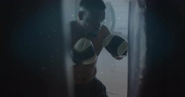 Erkek boksör spor salonuna giriyor ve spor yapmak için kum torbasına yumruk atıyor. Sporcu, fitness, antrenman, dinamik, kuvvet, hareket, kardiyo