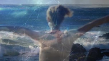 Kayalık Kıyı 'da kollarını kaldıran bir kadın dalgalar çarptığında teknolojik ağ kaplamasını başlatıyor. Açık hava, macera, fütürizm, bağlantı, huzur, minimalizm, teknoloji