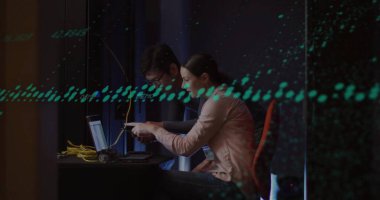 Atölyedeki sarı ethernet kablolarını dizüstü bilgisayarla bağlayan spor ceketler giyiyorlar. Profesyonel, takım çalışması, yenilik, ağ oluşturma, dijital, modern, kurumsal