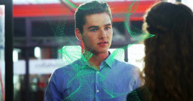 Mavi tişörtlü adam, transit istasyonunda yeşil kıvrımlı hologramlı bir kadınla karşı karşıya. Teknoloji, işbirliği, yenilik, fütürizm, iş dünyası, iletişim, ağ