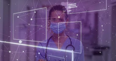 Hastane koridorunda önlük ve maske takmış steteskop ve dijital kaplamayla ayakta duran bir tıp çalışanı. Sağlık, teletıp, yenilik, profesyonellik, teknoloji, tıbbi, dijital