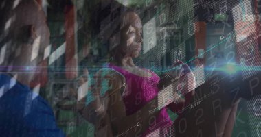 Spor salonunda kadın sporcu analitik kaplama ve antrenörle kablolu yayının kulplarını çekiyor. Fitness, strength, training, performance, analytics, technology, sport