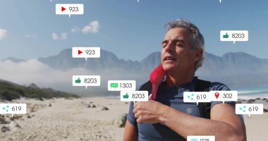 Sahilde üzerinde kırmızı ceket olan sırt çantası giyen gri saçlı yürüyüşçü, yüzen ikonlar, fotokopi alanı. Macera, keşif, doğa, esneklik, açık hava, teknoloji, manzara