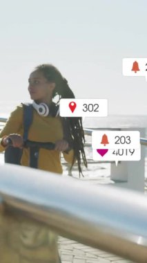 Deniz kenarındaki gezinti alanında yürüyen bir kadın hakkında sosyal medya bilgilendirmeleri. teknoloji, akıllı telefon, dijital, bağlantı, yaşam tarzı, açık hava