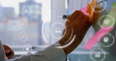 İş adamı cam üzerine pembe yapışkan nota basıyor, dizüstü bilgisayarı etkinleştiriyor, fikir düzenleyen analitik simgeleri oluşturuyor. Yenilik, işbirliği, dijital, beyin fırtınası, üretkenlik, modern, takım çalışması