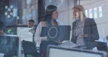 Spor ceketli iki iş kadınının bilgisayarı dijital kaplamayla ofise çevirdiği verileri tartışıyorlar. İşbirliği, takım çalışması, analitik, yenilik, modern, profesyonel, başlangıç