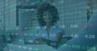 Mavi bluz giyen analist ofis masasında bilgisayar ve evrak işleriyle pazar verilerini tartışıyor. İş, finans, analitik, modern, profesyonel, kurumsal, veri odaklı