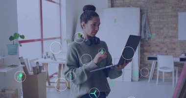 Dizüstü bilgisayar ve stil sahibi, yaratıcı kadın, parlak tavan arası stüdyosunda kulaklıkları olan tasarımlar çiziyor. Sanat eserleri, modern, tasvir edici, markalaştırıcı, yaratıcı, işbirlikçi, canlı