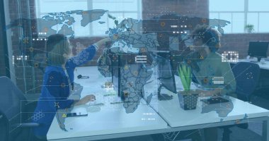 Mavi ceketli kadın ve iş arkadaşı çatı katındaki monitörleri işaret ediyor, akıllı telefonlu. İşbirliği, takım çalışması, teknoloji, modern, yenilik, profesyonel, çalışma alanı