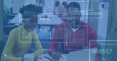 İki meslektaş süveter giyip konferans odasında dizüstü bilgisayardaki verileri analiz ediyor. İşbirliği, takım çalışması, yenilik, iletişim, modernlik, üretkenlik, dijital