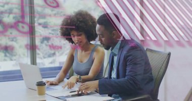 Konferans masasında dizüstü bilgisayarlı kalem bardağıyla basılı belgeleri inceleyen kadın ve uygun adam. İşbirliği, takım çalışması, profesyonellik, modernlik, iş dünyası, iletişim, çalışma alanı