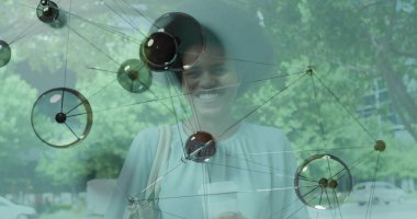 Şehir kaldırımında, cam yapının ortasında elinde kahve fincanı çantasıyla yürüyen bir kadın. Kentsel, moda, modern, yaşam tarzı, mimari, açık hava, aksesuarlar