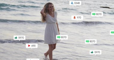 Beyaz kolsuz elbiseli gülümseyen kadın sahilde okyanusta saçlarını tarıyor, sosyal medya örtüleriyle. Okyanus, kıyı şeridi, sahil, dalga, akıntı, sükunet, rahatlık