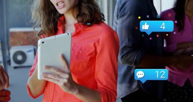 Sosyal medya baloncuklarının yükseldiğini gösteren tableti tıkırdatan kadın, ölçümleri tartışan meslektaş. İşbirliği, analitik, dijital, iletişim, profesyonel, teknoloji, takım çalışması