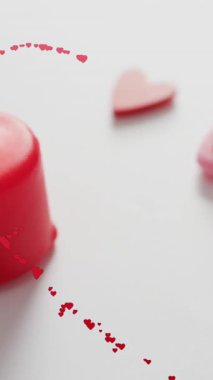 Beyaz arka planda mumların üzerinde kalp animasyonu. Sevgi ve kutlama konsepti dijital olarak oluşturulmuş video.