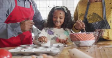 Çocuk kek tepsisinde yumurta kırıyor, büyükanne ve büyükbaba yemek pişirmek için yumurta döküyor ve karıştırıyor. Aile, yemek pişirme, pişirme, gelenek, jenerasyon, aşçılık, yerli