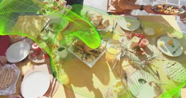 Arkadaşların teras masasından tavuk uzatıp konukseverlikle salata servis etmesi. Yemek, açık hava, köy, kutlama, dostluk, sosyalleşme, coşku.