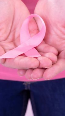 Kafkasyalı bir kadının pembe kanser farkındalığı kurdelesi taşıdığı bir video. Göğüs kanseri pozitif farkındalık kampanyası konsepti.