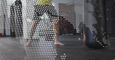 Yeşil tişörtlü adamı spor salonunda boks yaparken, kum torbasıyla, dünya haritası üzerinde. Fitness, antrenman, dövüş sanatları, dövüş, güç, çeviklik, dijital grafikler