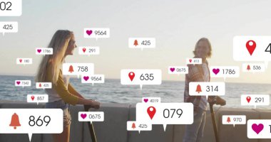 Deniz kenarındaki gezinti alanında, yüzen sosyal medya simgeleriyle elektrikli scooterların üzerinde duran bir çift. Romantik, macera, eğlence, modern, canlı, teknoloji, bağlantı