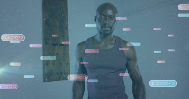 Stüdyoda kolsuz tişört giyen, yüzen sayısal üstleri ve tahta kirişleri olan ayakta duran bir atletik. Gelecekçi, teknoloji, dijital, arayüz, yenilik, minimalist, konsantrasyon