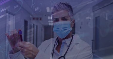 Hastane koridorunda elinde kan tüpü olan, ameliyat maskesi takan kıdemli bir doktor. Tıbbi, sağlık, teknoloji, klinik, tanı, profesyonellik, gelecekçilik