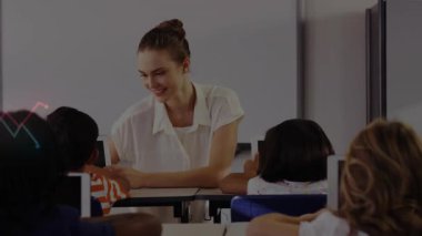 Sınıfta öğrencilere tabletlerde rehberlik eden bayan öğretmen, ilerlemeyi gösteren grafikleri aktifleştiriyor. Eğitim, teknoloji, öğrenme, sınıf, yenilik, iletişim, bağlılık