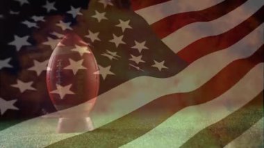 Amerikan futbol topunun üzerinde Amerikan bayrağı ve alevleri sallama animasyonu. küresel spor ve yarışma konsepti dijital olarak oluşturulmuş video.