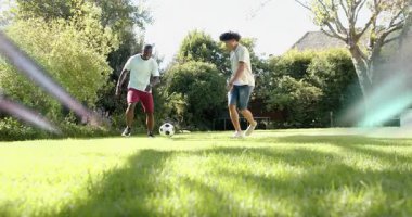 İki adam topu yerleştiriyor ve hareketli ayak hareketleri ve hız grafiğiyle salyalarını akıtıyor. Atletizm, takım çalışması, açık hava, canlı, tutku, çeviklik, eğitim