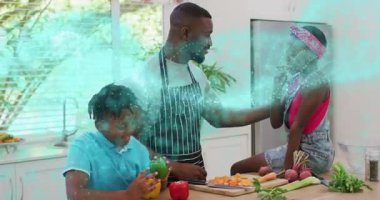 Babamın sebze doğraması sağlıklı pişirme sırasında ailenin etrafında dönen turkuaz ışığı tetikliyor. Aile, mutfak, aşçılık, sebzeler, birliktelik, sağlıklı yaşam tarzı, modern