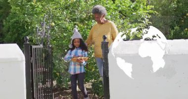 Büyükannem, bahçe kapısını açan kızı elinde sepetle tarımın altındaki meyveleri tadıyor. Aile, miras, masumiyet, yetiştirme, keşfetme, kırsal, canlı