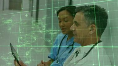 Doktor, yeşil holografik ızgarayı sağlık verileri incelemesi için eğip inceledikten sonra tableti tutuyor. Tıbbi, işbirliği, fütüristik, sağlık, dijital, yenilik, teşhis