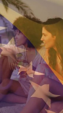 Sahilde oturan, yıldız animasyonu yapan bir grup arkadaş. Arkadaşlık, açık hava, tatil, yaz, boş zaman, mutluluk.